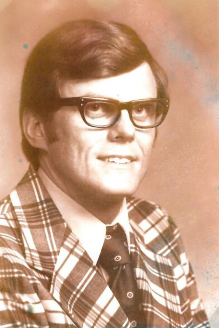 An old photo of a man wearing glasses and a plaid suit at Lakewood, Colorado.