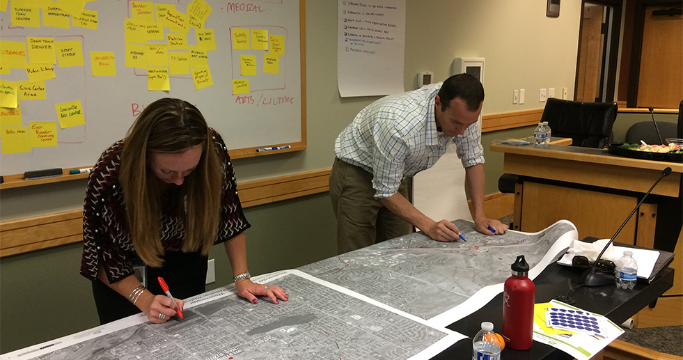 Two people collaborating on a map in a conference room, utilizing services.
