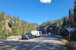 A truck driving down US 160, a mountain road, with a RV parked next to it near Wolf Creek Tunnel.
