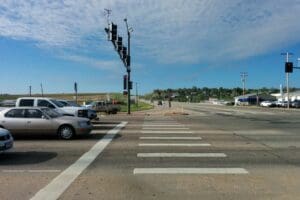 A street with parked cars, requiring prioritization at the intersection.