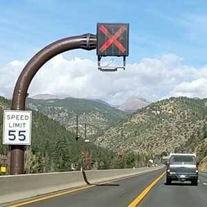 A car driving down I-70 with a speed limit sign.